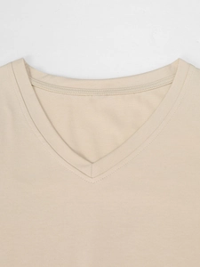 Detail van de V-hals met versterkte stiksels op een beige minimalistisch katoenen T-shirt