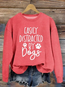 Detail of the white lettering and paw prints on a rust red crewneck sweatshirt