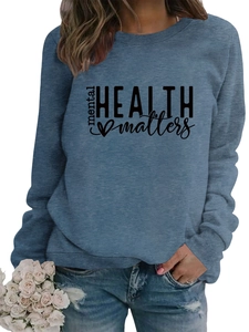 Close-up of mental HEALTH matters printed slogan on a soft blue crewneck sweatshirt