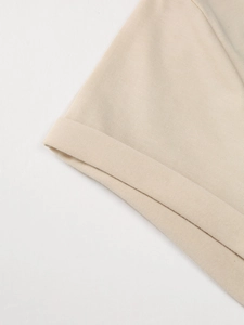 Gedetailleerde macro-opname van de rolzoom op een beige V-hals gebreid katoenen T-shirt