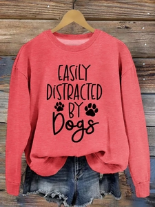 Detail of Easily Distracted by Dogs print on red long sleeve crewneck sweatshirt
