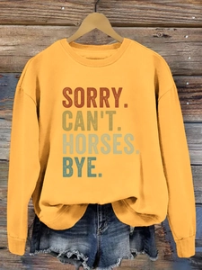 Détail de l'imprimé Sorry Can't Horses sur un sweat-shirt jaune à manches longues