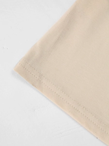 Macro-opname van de dubbele zoomstiksels op een beige katoenen T-shirt met V-hals