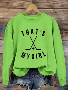 Détail du sweat vert col rond avec imprimé THAT'S MY GIRL noir sur fond en bois rustique