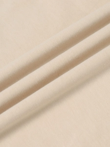 Detailopname van beige katoenen V-hals stof met zachte gebreide textuur en afwerking