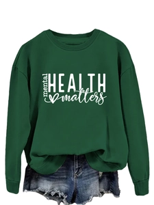 Detail of Mental Health Matters print on a dark green crewneck sweatshirt with denim shorts