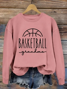 Close-up of Basketball Grandma print on dusty pink crewneck sweatshirt with denim styling