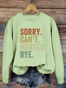Gros plan sur l'imprimé SORRY CAN'T HORSES BYE d'un sweat à col rond vert menthe