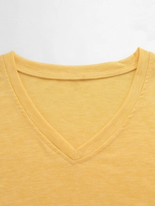 Close-up van de V-hals van een geel T-shirt met korte mouwen en gebreide textuur