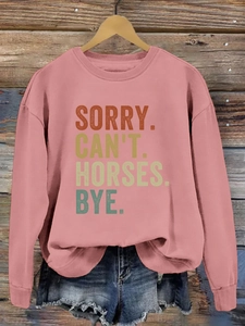 Détail de l'imprimé SORRY CAN'T HORSES sur un sweat-shirt rose à manches longues