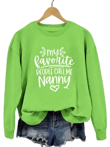 Détail d'un sweat vert citron avec impression de texte blanc et col rond classique