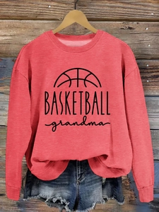 Close-up of Basketball Grandma print on a coral red crewneck sweatshirt with denim shorts