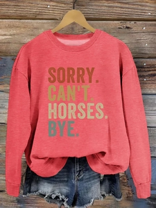 Détail de l'encolure côtelée et de l'imprimé slogan sur un sweat-shirt équestre décontracté