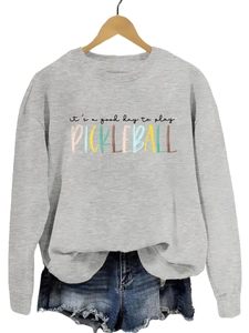 Close-up of the colorful 'it's a good day to play pickleball' print on a gray sweatshirt