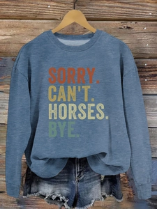 Détail de l'imprimé SORRY CAN'T HORSES sur un sweat-shirt bleu-gris avec cintre en bois