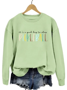 Close-up of sage green sweatshirt with Good Day to Play Pickleball colorful print