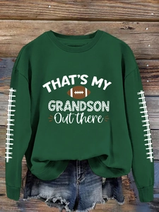 Détail de l'imprimé rugby et des coutures de football blanches sur le sweat-shirt vert
