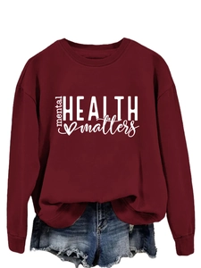 Detail of burgundy sweatshirt featuring mental health matters text and heart graphic print
