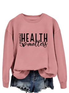 Close-up of Mental Health Matters text print on pink long sleeve pullover sweatshirt
