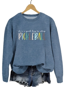 Close-up of blue pickleball crewneck sweatshirt with white and colorful text graphic