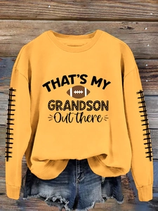 Détail du sweat-shirt jaune avec imprimé football et bandes décoratives aux manches