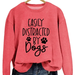 Red crewneck sweatshirt with black Easily Distracted By Dogs print on wooden hanger