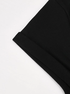 Detailopname van zwarte gebreide top met V-hals en dubbelgevouwen mouwafwerking