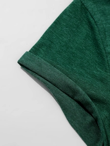 Detail van de donkergroene gemêleerde stof en de omgeslagen mouw van dit V-hals shirt