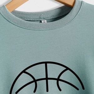 Teal crewneck sweatshirt featuring a minimalist black basketball graphic on a wooden hanger