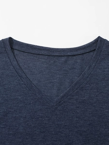 Detailopname van de V-hals met nauwkeurige dubbele stiksels op een marineblauw T-shirt
