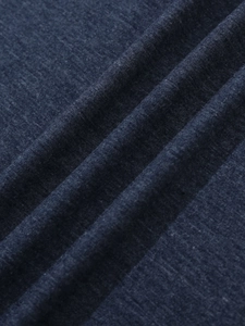 Macro-opname van de marineblauwe gebreide stoftextuur met zachte vouwen en gevlekte korrel
