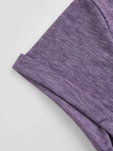 Detail van de opgerolde manchet op een paars gemêleerd gebreid shirt met textuur