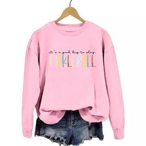 Pink sweatshirt with Pickleball rainbow print and denim shorts on wooden hanger