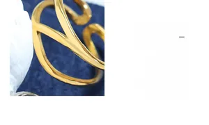 Macro shot of 18k gold plated titanium ring with elegant wavy and curved design details
