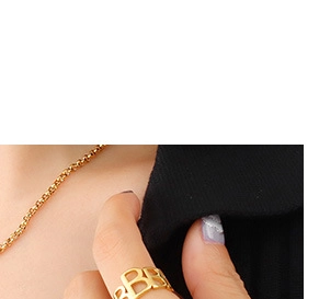 Vue détaillée d'une bague dorée ajourée avec lettre 'B' et collier à chaîne assortie