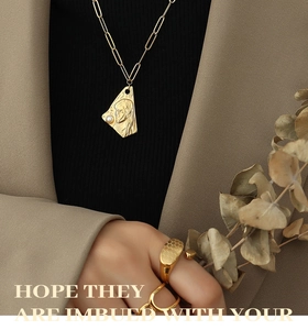 Détail d'un collier doré vintage avec pendentif en relief et une perle de baroque