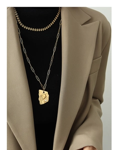 Détail d'un collier doré multicouche avec pendentif portrait et perle sur mannequin
