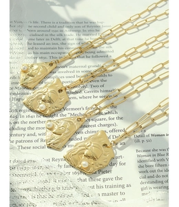 Détail du pendentif baroque doré avec relief artistique et perle sur collier