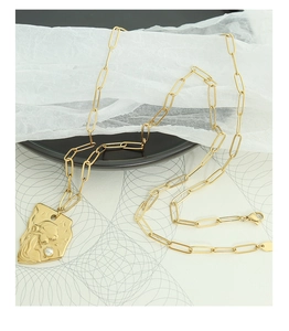 Détail du collier chaîne trombone avec médaille portrait dorée et perle baroque