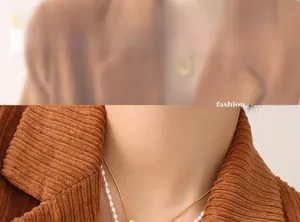 Detail einer geschichteten goldenen Schlangenkette und Perlenkette getragen von einem Modell