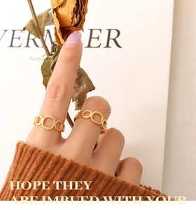 Detail of gold geometric hollow square ring with matte finish on finger for fashion look