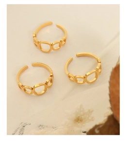 Three gold square hollow rings displayed on textured paper with dried flower details