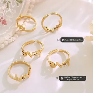 Lot de cinq bagues réglables dorées avec motifs couronne et LOVE en présentation chic