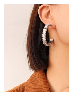 Détail des boucles d'oreilles créoles argentées avec zircons étincelants taille baguette