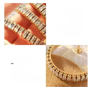 Détail de boucles d'oreilles en forme de C en acier titane plaqué or 18K et zircons