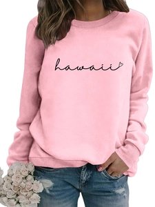 Detail of pink long-sleeved sweatshirt featuring a black Hawaii script and heart print