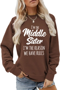 Detail of ribbed cuffs and white slogan print on brown long sleeve sweatshirt
