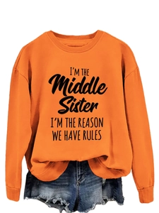 Detail of orange sweatshirt featuring I'M THE MIDDLE SISTER bold printed text and ribbed cuffs