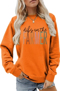 Detail of orange crewneck sweatshirt with Dibs on the Farmer print and fabric texture