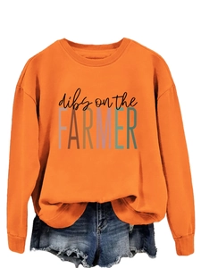 Flat lay of orange crewneck sweatshirt with Dibs on the Farmer text and denim shorts